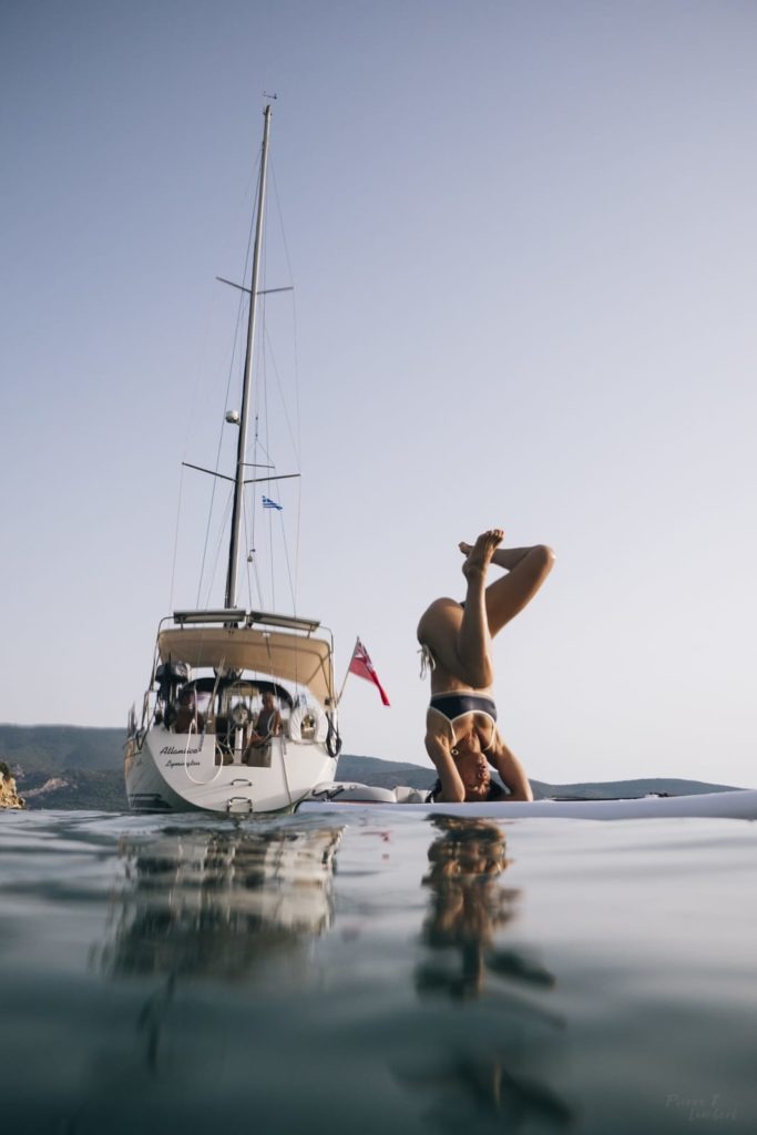 stand up paddle in greece on a sailboat
